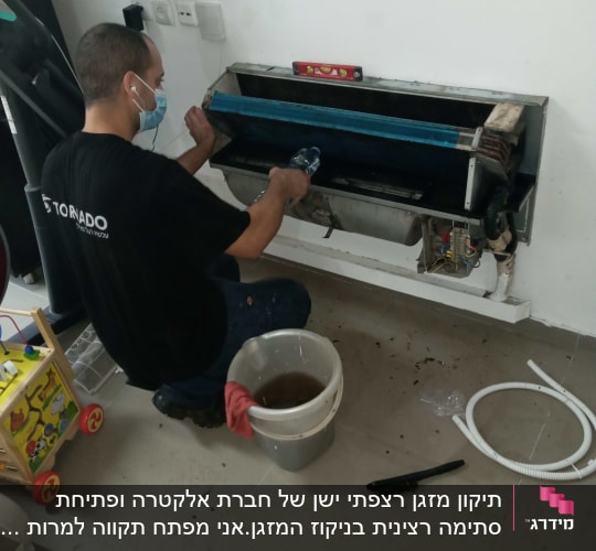 טכנאי מנקה מזגן עם מברשת ודלי מים